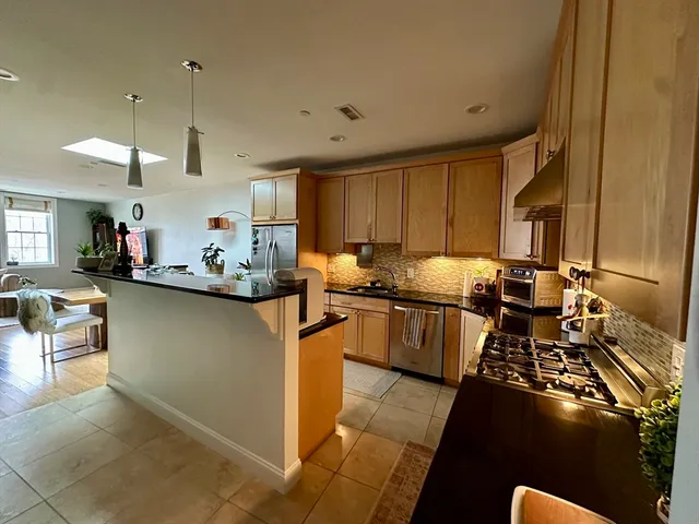 a kitchen with a refrigerator and a stove top oven