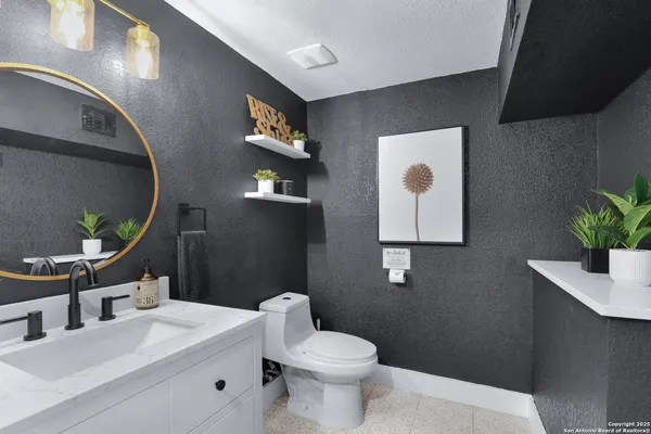 a bathroom with a toilet sink and mirror