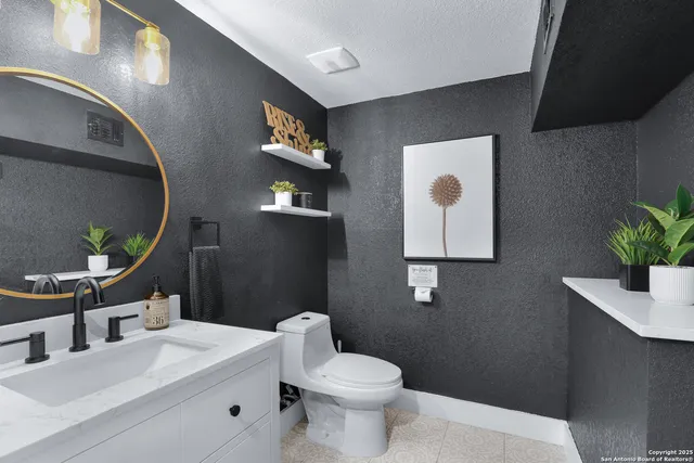 a bathroom with a toilet sink and mirror