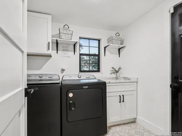 a utility room with sink dryer and washer