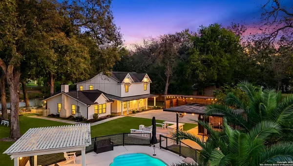 an aerial view of a house with swimming pool and furniture