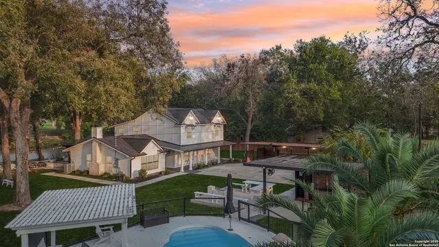 a view of a house with a yard deck and a large tree
