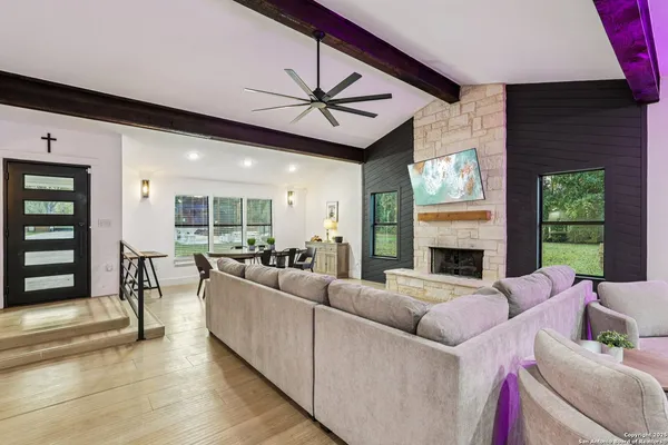 a living room with furniture a fireplace and a large window