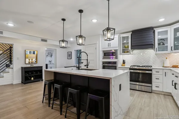 a kitchen with stainless steel appliances granite countertop a stove a sink and a refrigerator