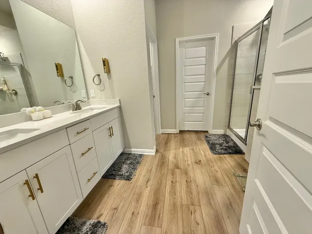 a bathroom with a sink a toilet a large mirror and shower