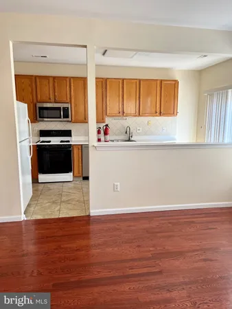 a view of kitchen with wooden floor and electronic appliances