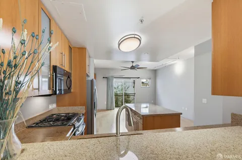 a kitchen with stainless steel appliances granite countertop a sink a stove and a granite counter tops with a large window