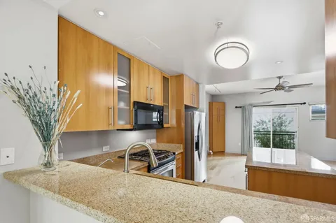 a kitchen with granite countertop a sink stainless steel appliances and cabinets