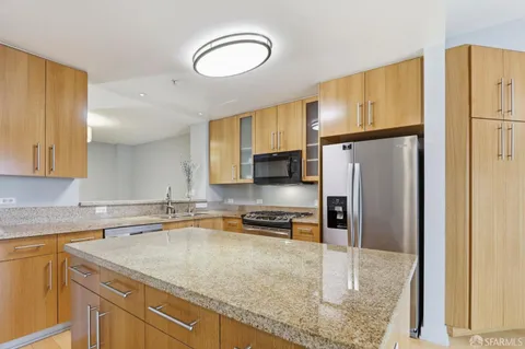 a kitchen with a refrigerator a sink and cabinets