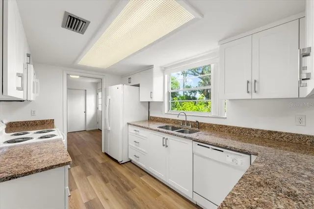 a kitchen with granite countertop a sink and a window
