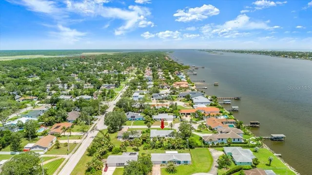 a view of a house with a yard and palm trees