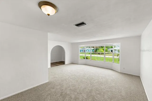 an empty room with a fireplace and a large window