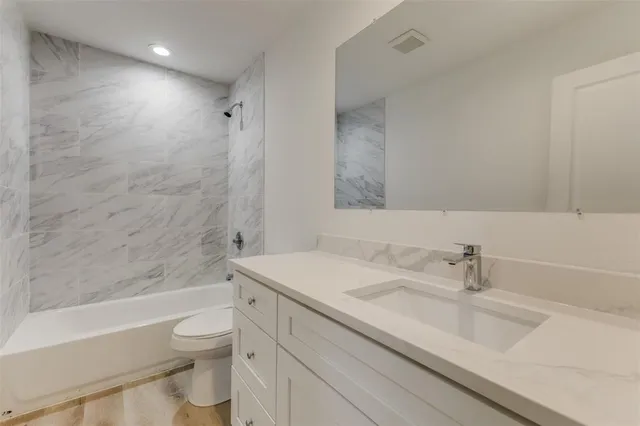 a bathroom with a sink toilet vanity and shower