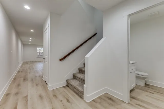 a view of a hallway with wooden floor and staircase
