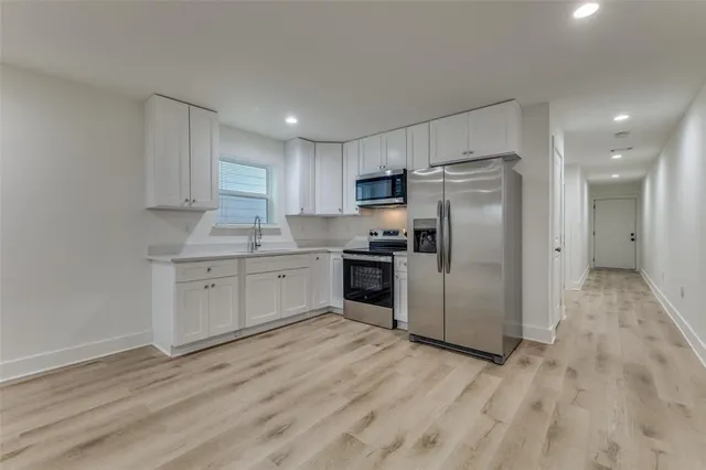 a kitchen with a refrigerator a sink and cabinets