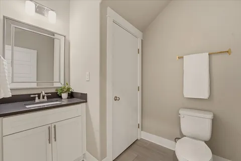a bathroom with a granite countertop toilet sink and mirror