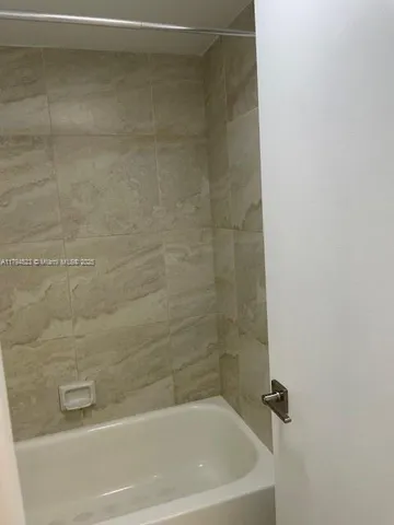 a bath tub sitting next to a white sink and a shower