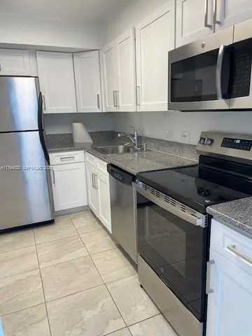 a kitchen with a sink and a stove top oven