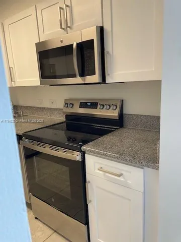 a kitchen with stainless steel appliances granite countertop a stove microwave and oven