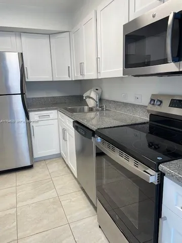 a kitchen with a sink and a stove top oven