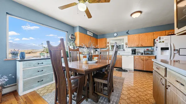 a kitchen with stainless steel appliances kitchen island granite countertop a table chairs and a refrigerator