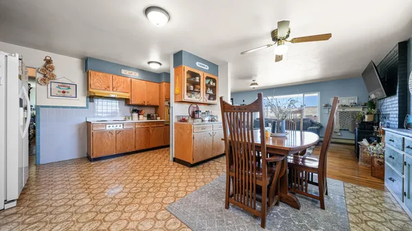 a kitchen with stainless steel appliances a table chairs and a refrigerator