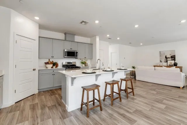 a kitchen with a sink white cabinets and stainless steel appliances