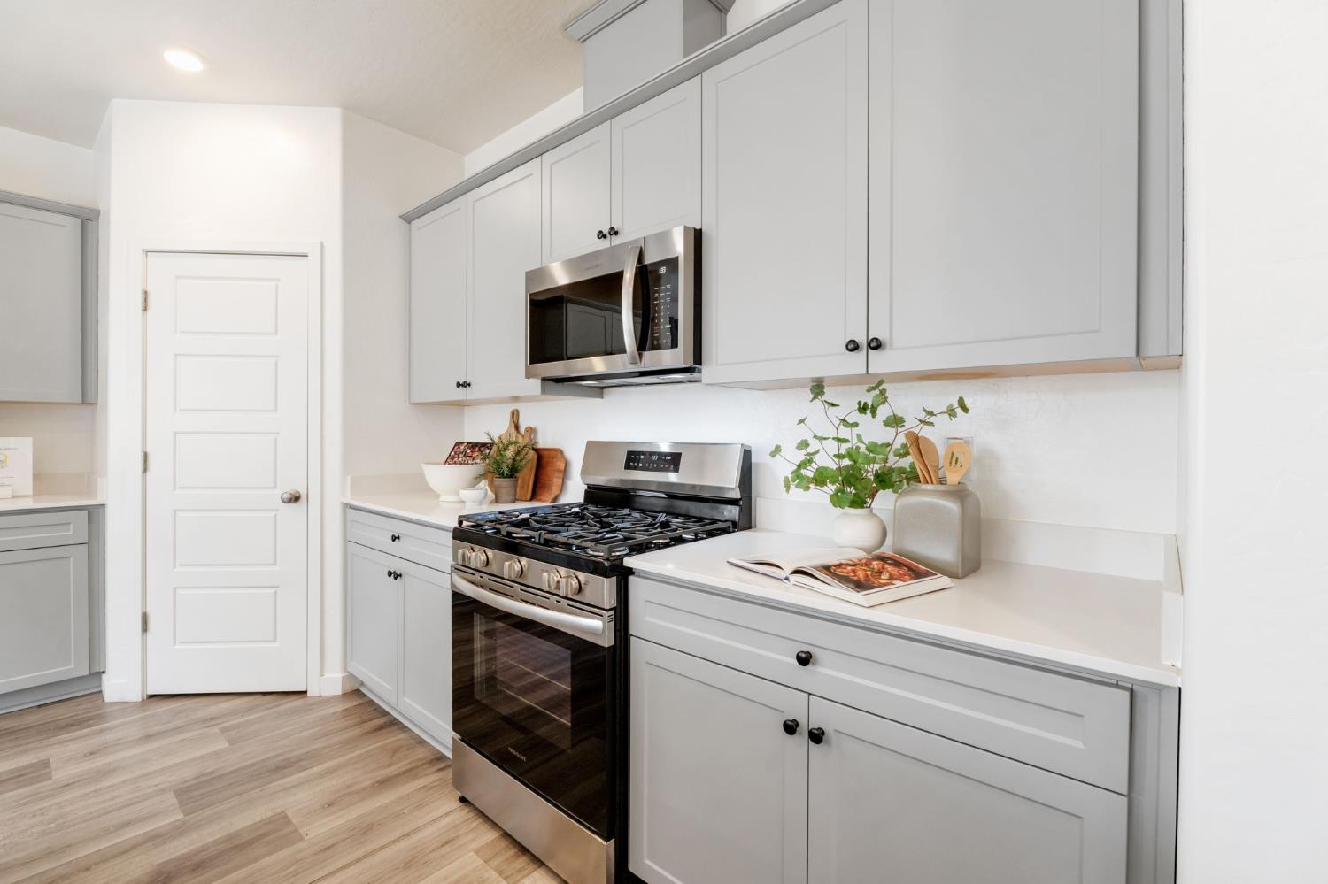 2819 North Redda Road Fresno, CA 93737 - Photo 17 of 57 a kitchen with stainless steel appliances white cabinets and a stove top oven