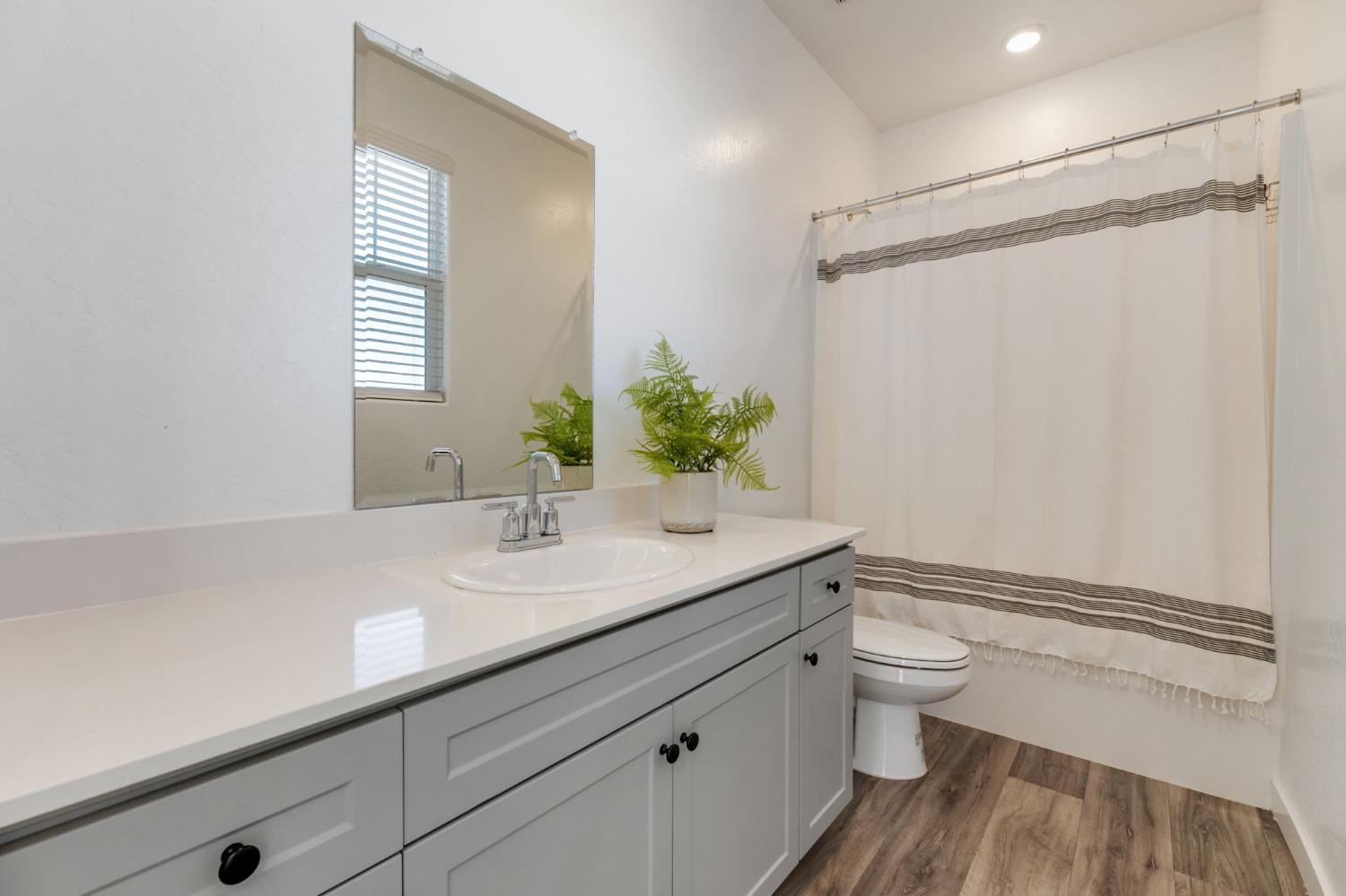2819 North Redda Road Fresno, CA 93737 - Photo 25 of 57 a bathroom with a granite countertop sink toilet and shower