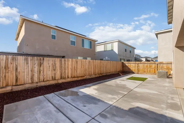 a backyard of a house with yard and wooden fence