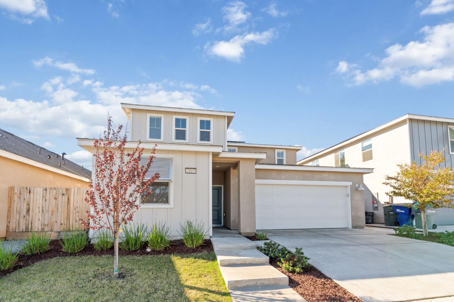 2819 North Redda Road Fresno, CA 93737 - Photo 4 of 57 a front view of a house with a yard and garage