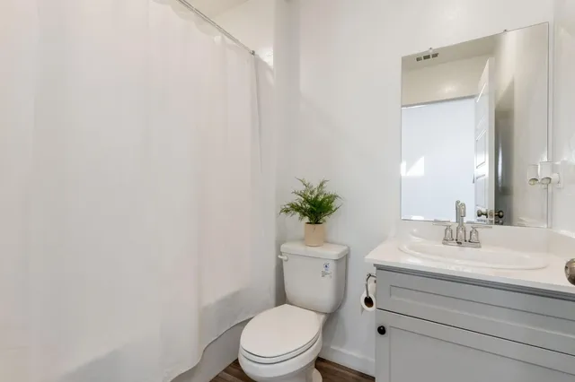 a bathroom with a sink a toilet a mirror and vanity