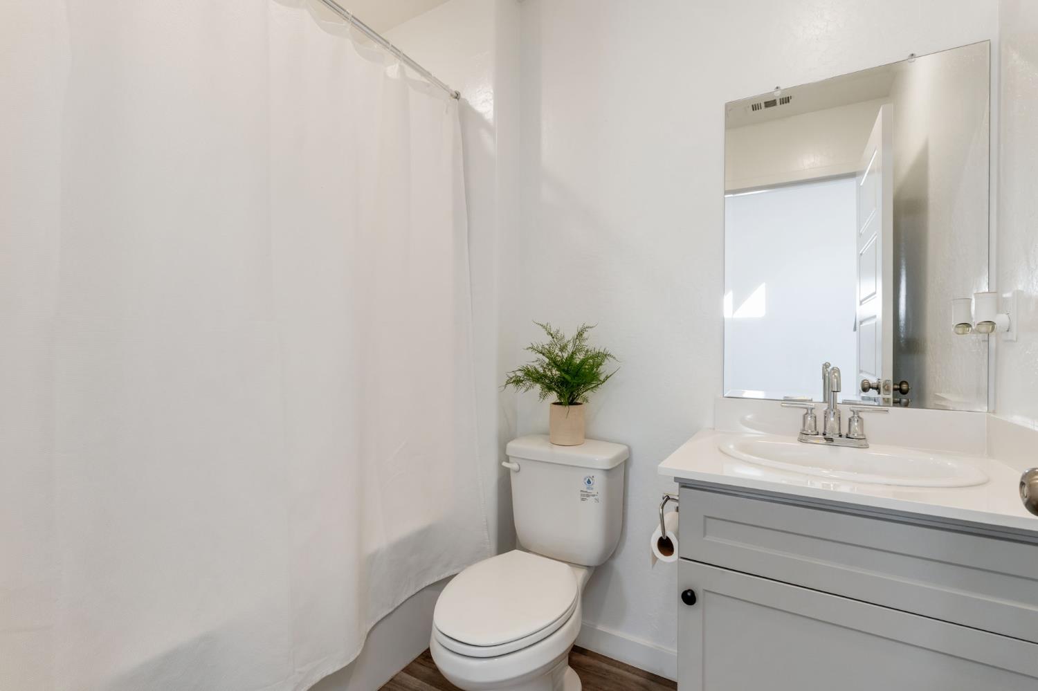 2819 North Redda Road Fresno, CA 93737 - Photo 7 of 57 a bathroom with a sink a toilet a mirror and vanity