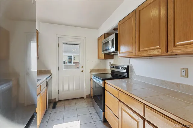 a kitchen with stainless steel appliances granite countertop a refrigerator and a stove