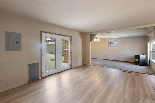 an empty room with wooden floor and windows