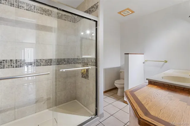 a bathroom with a granite countertop sink a toilet and shower