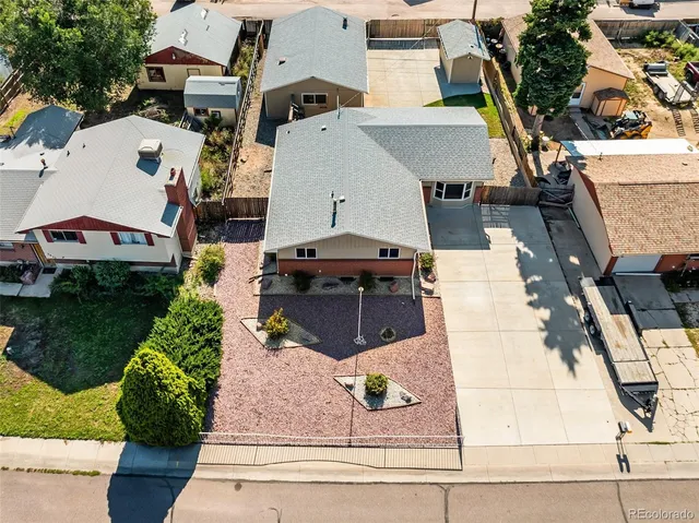 an aerial view of residential houses with outdoor space and trees