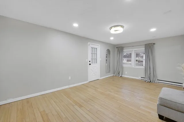 a view of empty room with wooden floor