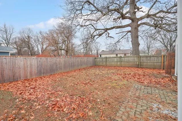 a view of a white house with large windows and wooden fence