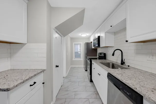 a kitchen with stainless steel appliances granite countertop a sink and a stove
