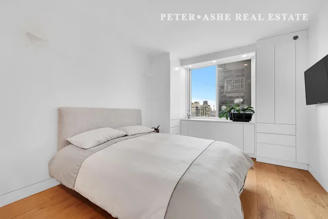 a kitchen with stainless steel appliances granite countertop a stove top oven a sink dishwasher and white cabinets with wooden floor