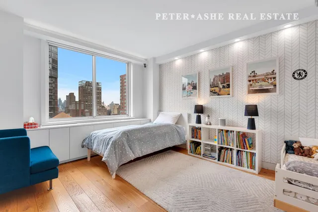 a bedroom with a bed and a flat tv screen on the dresser