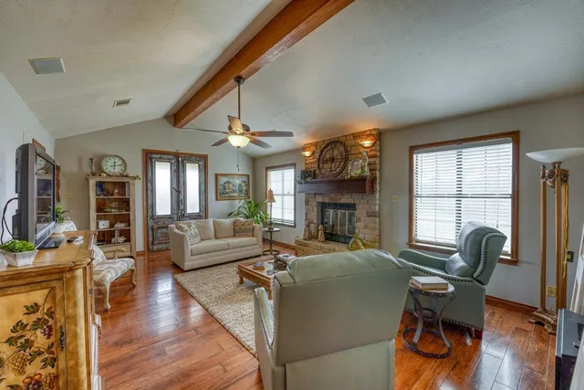a living room with fireplace furniture and a wooden floor