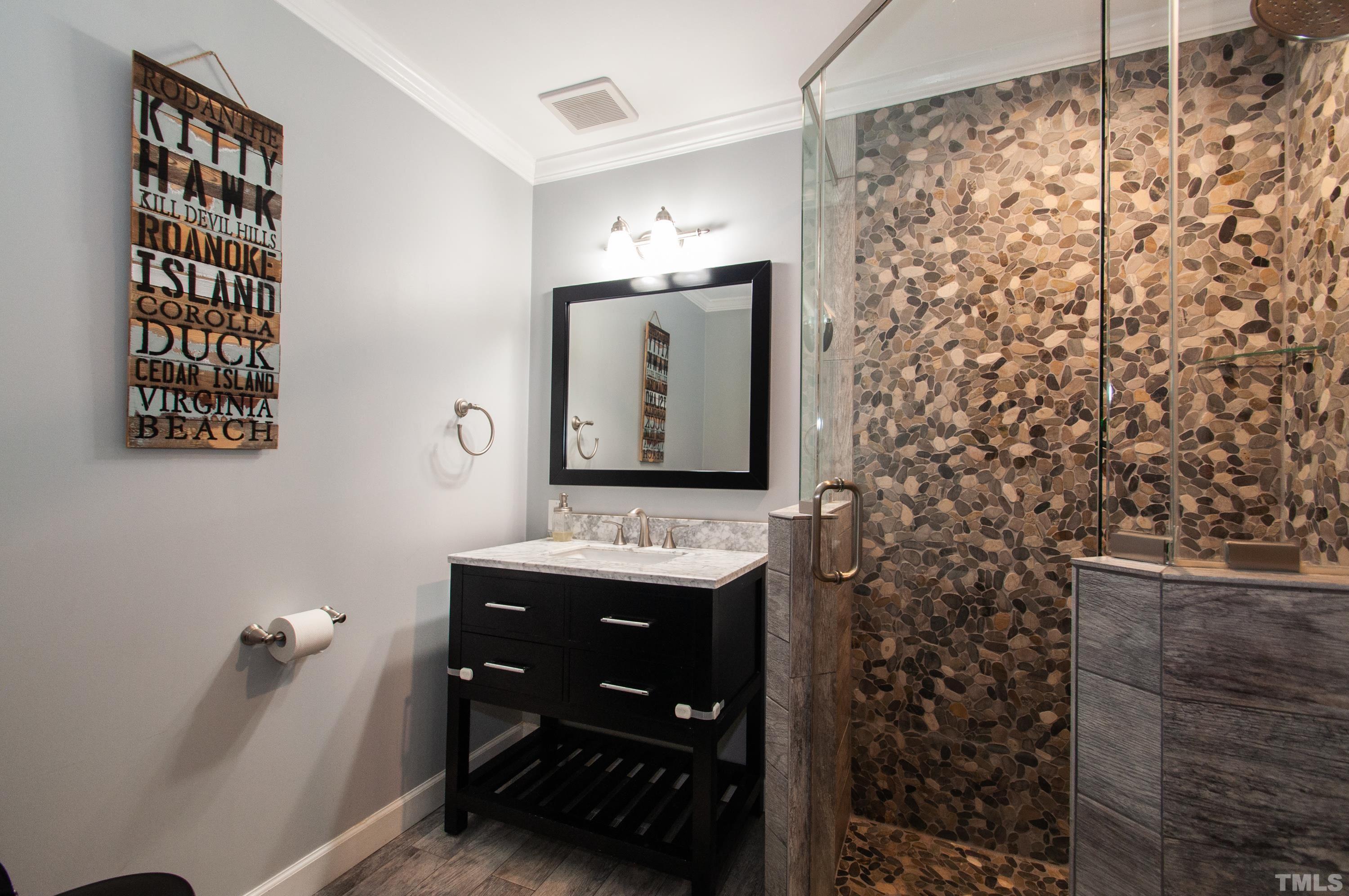 7901 Hepworth Court Raleigh, NC 27615 - Photo 13 of 30 a bathroom with a sink a mirror and shower