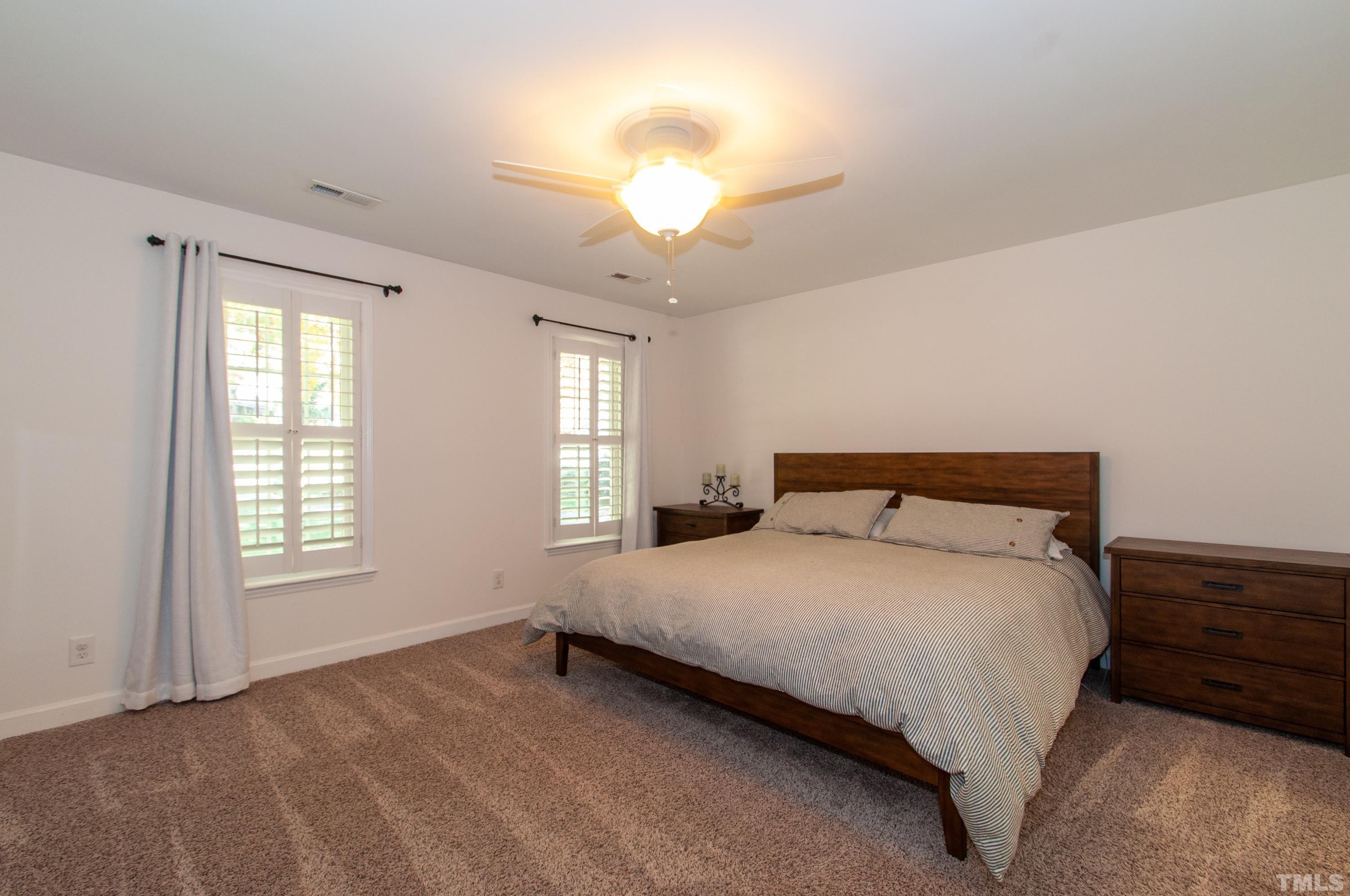 7901 Hepworth Court Raleigh, NC 27615 - Photo 15 of 30 a bedroom with a bed and a chandelier