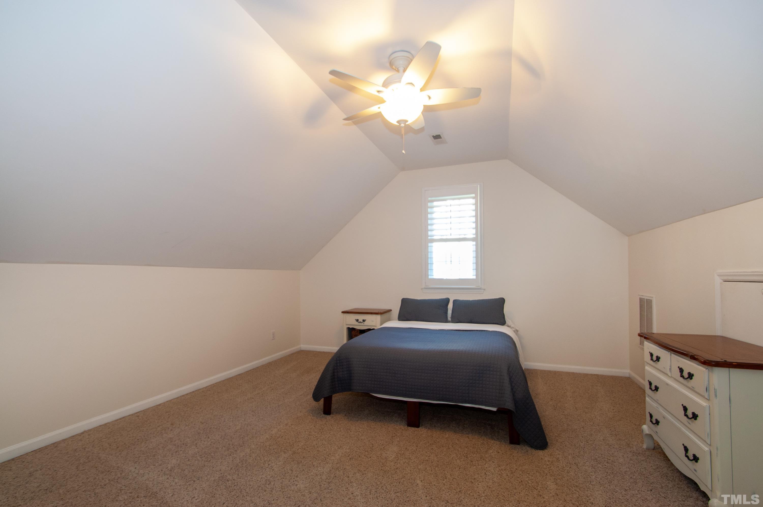 7901 Hepworth Court Raleigh, NC 27615 - Photo 22 of 30 a spacious bedroom with a bed and a chandelier