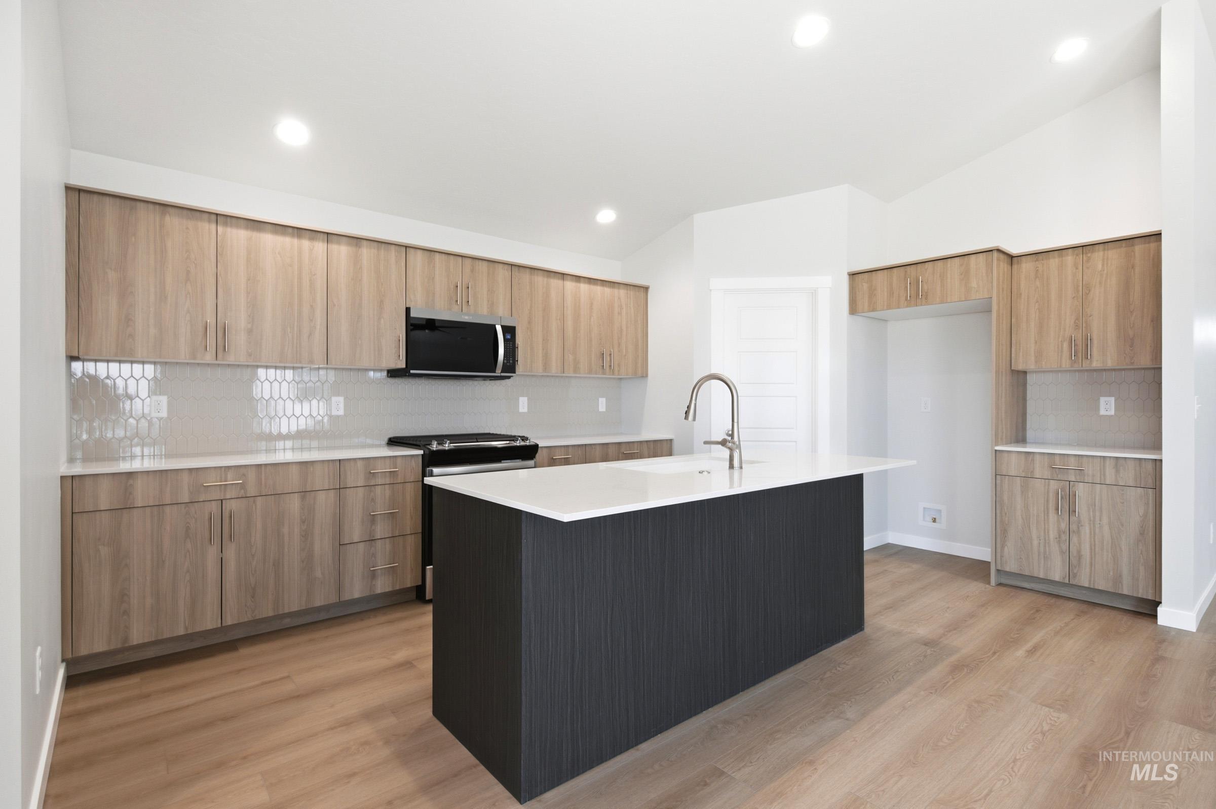 1184 West Jasper Street Meridian, ID 83642 - Photo 5 of 18 Modern kitchen featuring a central island with a white countertop and a gooseneck faucet
