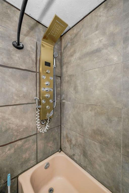 6126 Tennessee Avenue New Port Richey, FL 34653 - Photo 19 of 28 a bathroom with a white bath tub and shower