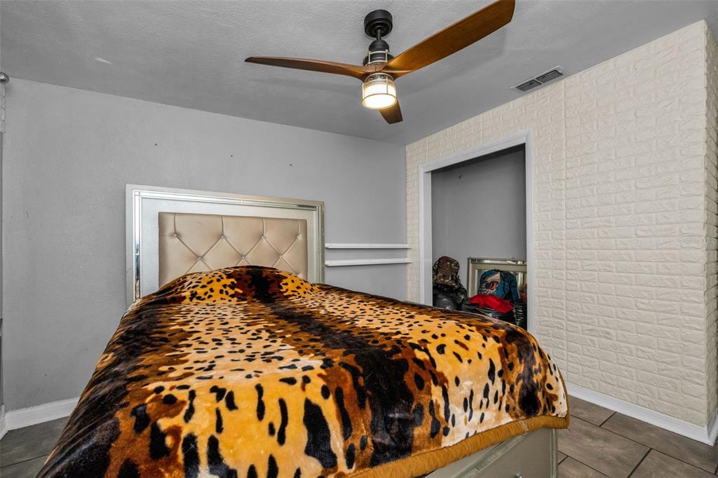 6126 Tennessee Avenue New Port Richey, FL 34653 - Photo 24 of 28 a bedroom with a bed and a chandelier