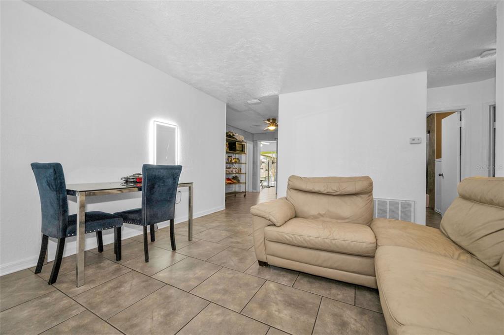 6126 Tennessee Avenue New Port Richey, FL 34653 - Photo 8 of 28 a living room with furniture a desk and chair